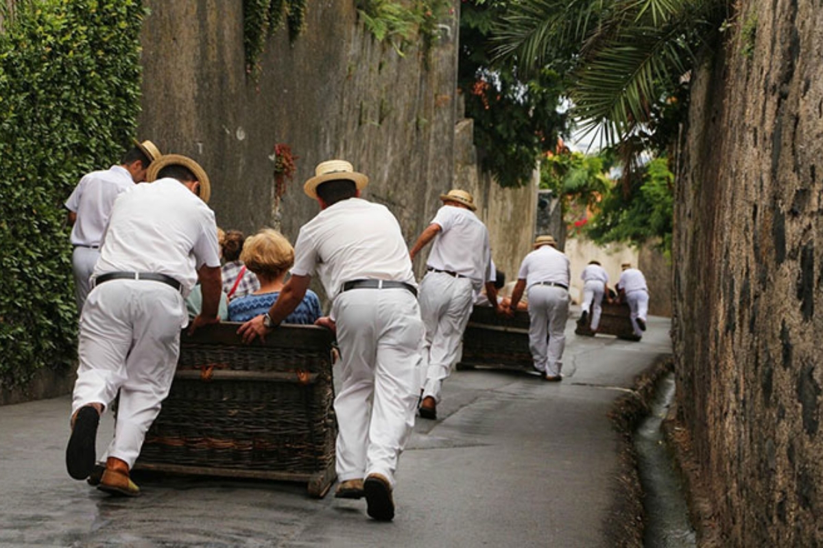 Traditional Monte toboggan wicker sled ride Madeira with carreiros in white