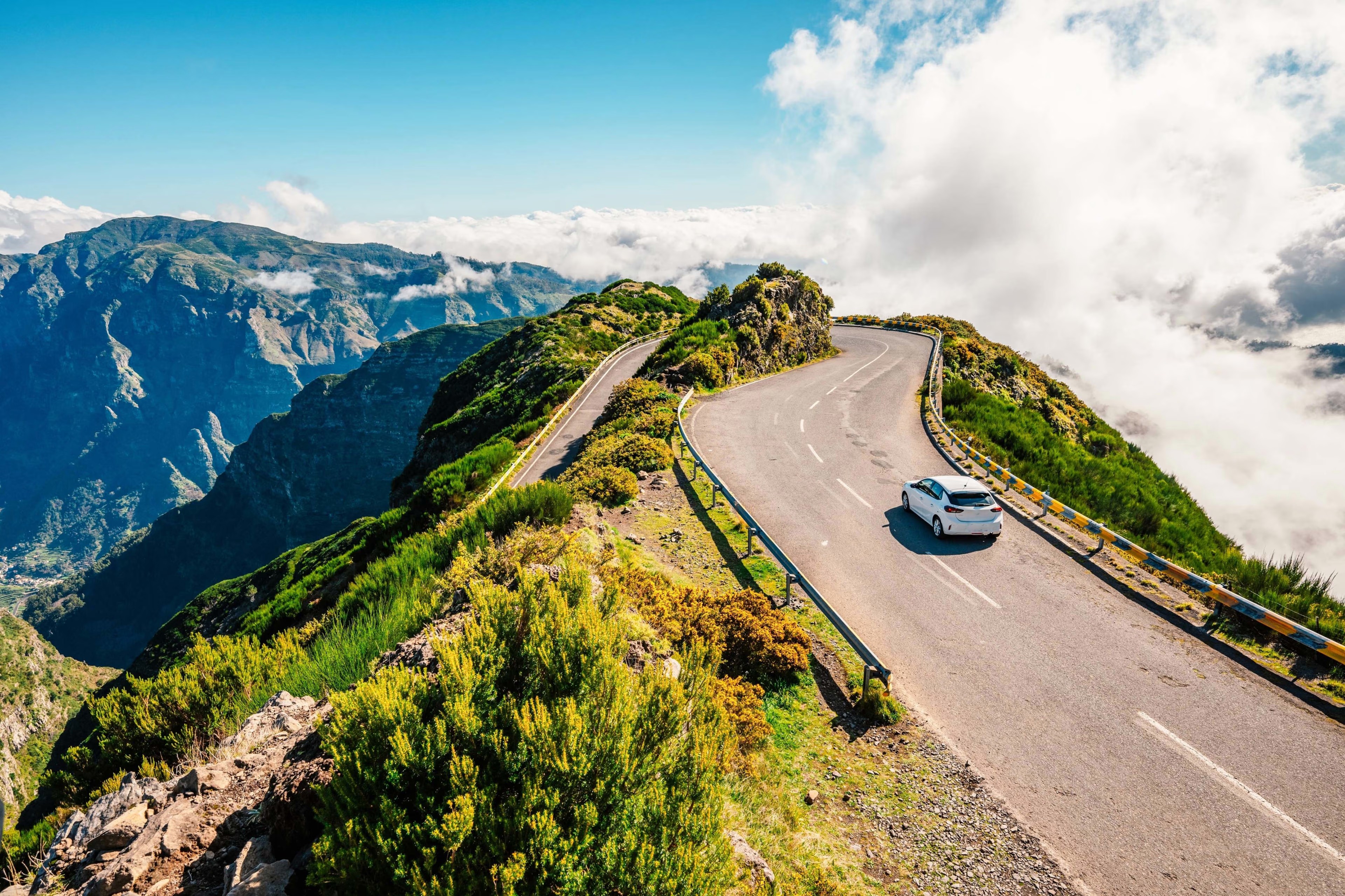Car driving on a mountain road above the clouds in Madeira